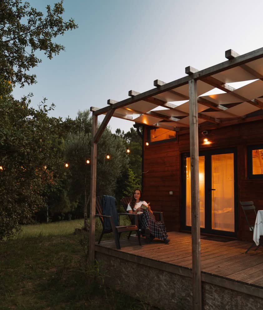A tiny house A Branda com a sua esplanada iluminada ao entardecer